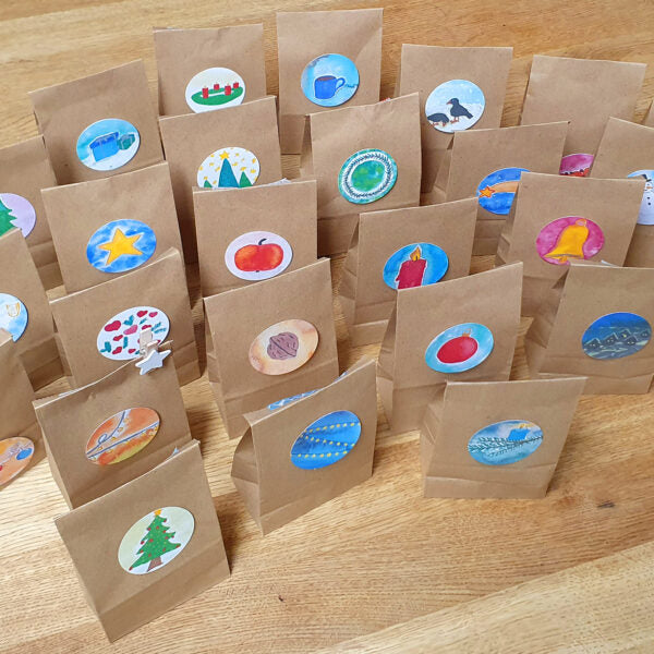 Vorbereiteter Rätsel-Adventskalender mit Papiertütchen und Sternklammern